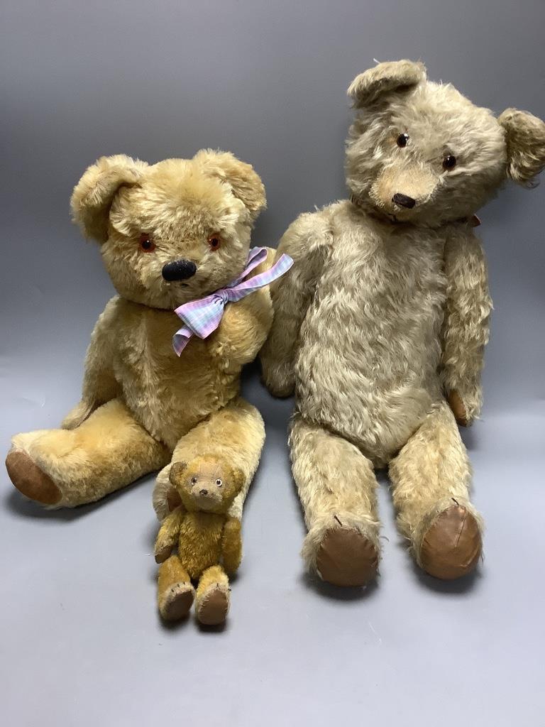 A vintage large plush jointed teddy bear with glass eyes and long muzzle, a later smaller jointed bear and a similar miniature bear, length 58cm